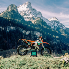 Moto d’enduro KTM posée en montagne avec paysage alpin en arrière-plan