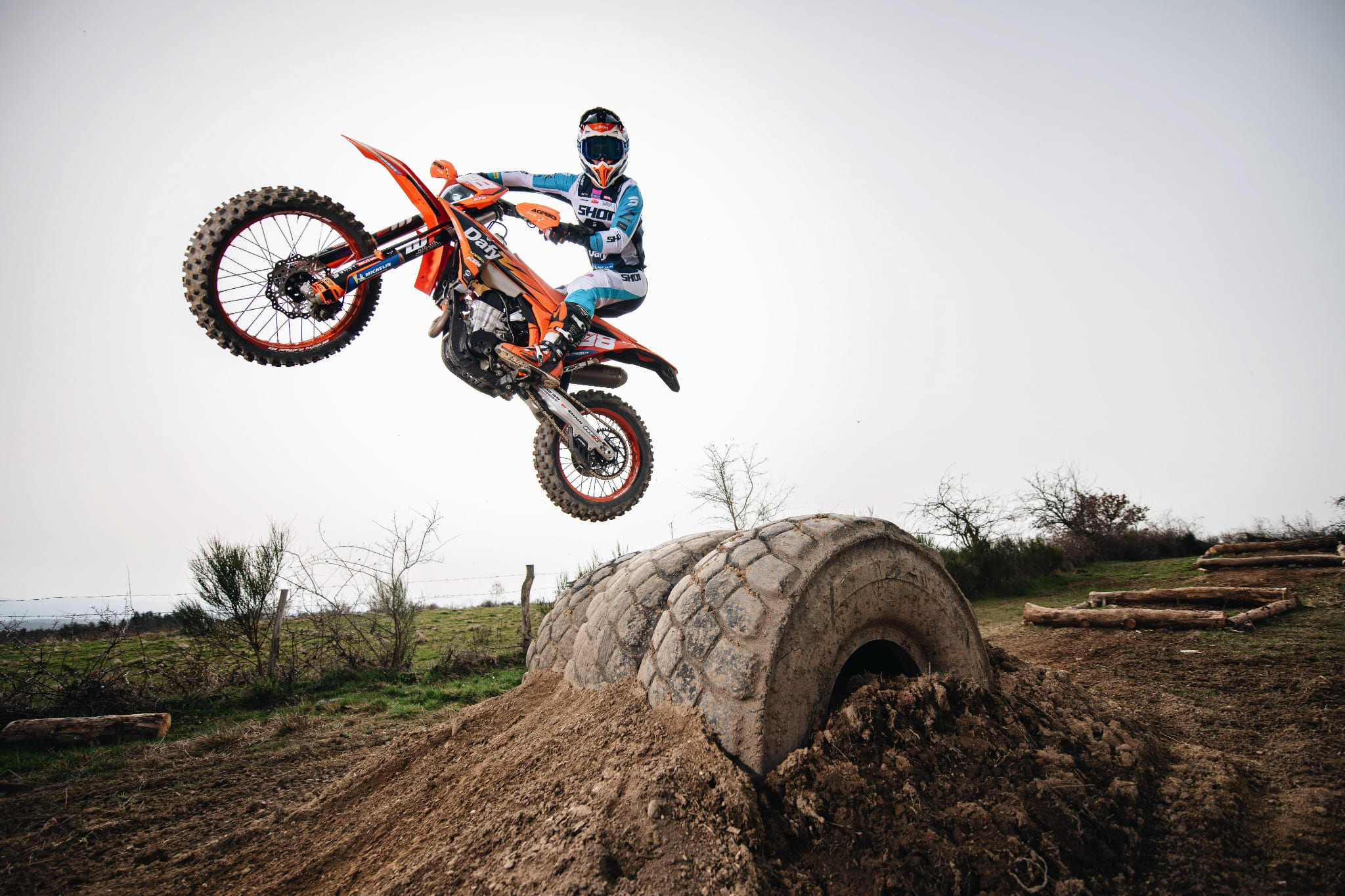 Pilote d’enduro KTM Dafy Moto réalisant un saut spectaculaire sur un terrain tout-terrain avec obstacle en béton.